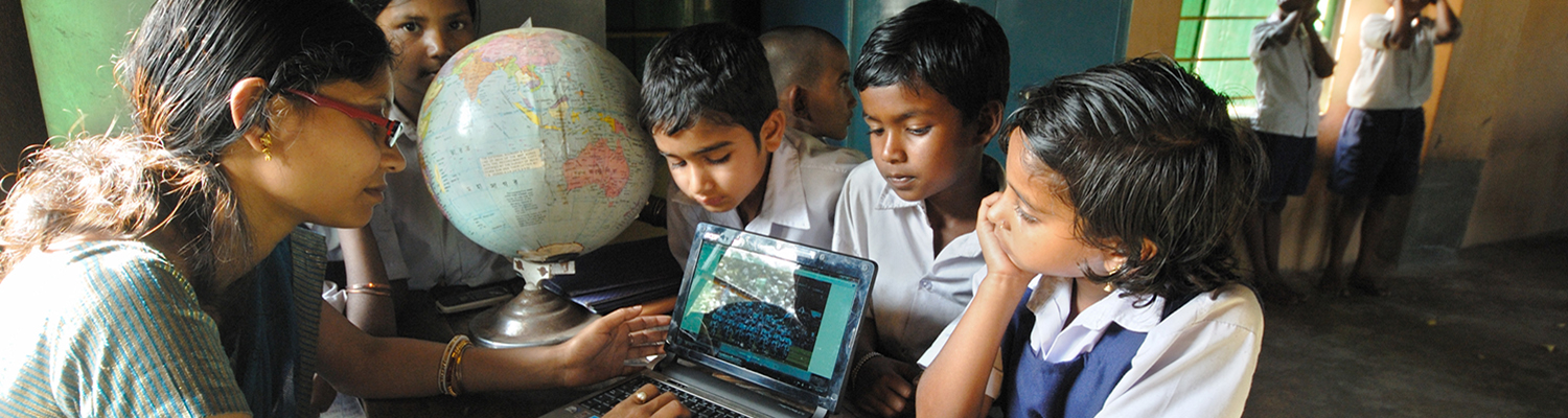 School teacher teachers her students with the help of a laptop at the rural school (West Bengal, India). 
