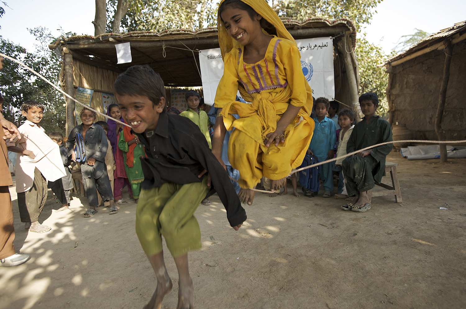 East Indian school boy and girl playing jumprope.