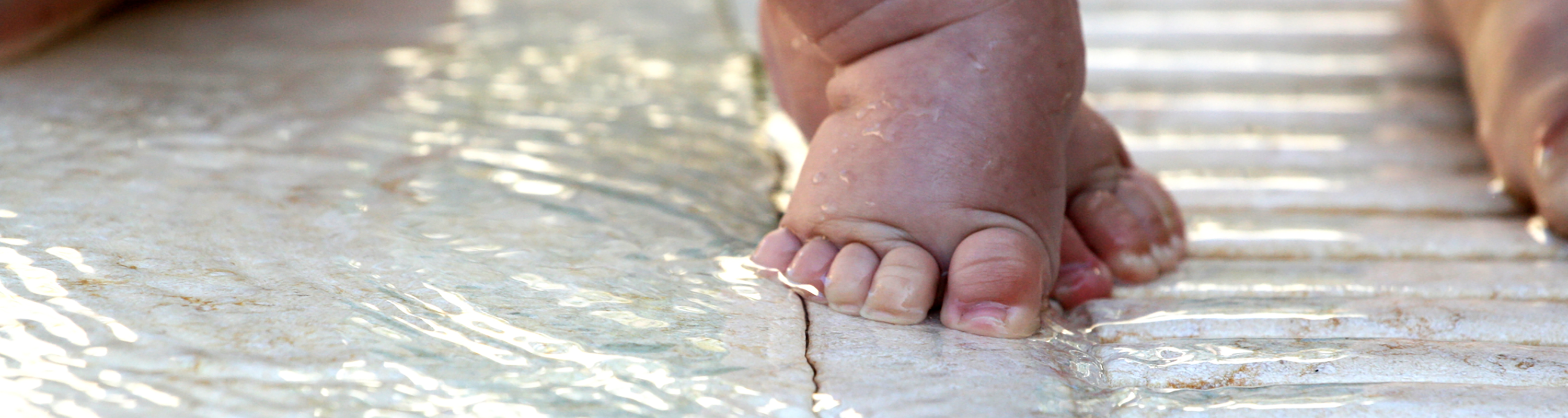Baby's first steps in a shallow pool of water. © Keki | Dreamstime Images