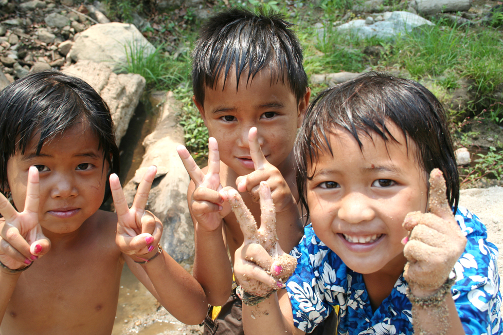 Three young Polynesian children making hand peace sign gestures. © Pathathai Chungyam | Dreamstime