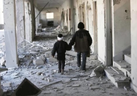 Two children walked through the corridors of a destroyed school last November in Eastern Ghouta, Syria. A United Nations report found that 80 percent of the country’s youth are in urgent need of humanitarian aid because of the conflict. Credit Save the Children, via Associated Press  