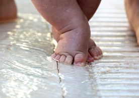 Baby's first steps in a shallow pool of water. 