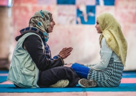   A young Syrian refugee (right) who fled to Jordan listens to a teacher (left) as part of a Mercy Corps youth program. SEAN SHERIDAN/MERCY CORPS