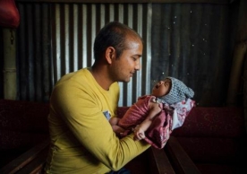 A father holds his 22-day-old son who was born in the period between the first and second earthquakes in Nepal this year.