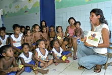 Teacher reads from storybook to school children (Brazil).
