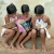 Three school girls read yet colorful childrens books with lots of pictures, drawings (State of Bahia in the North-East region, Brazil). 