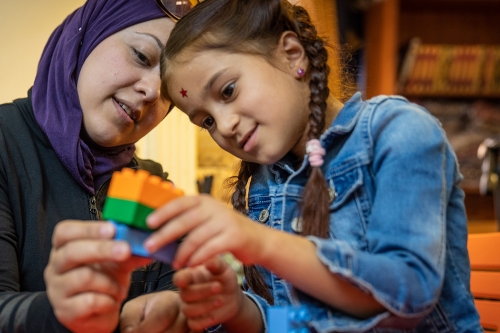 Mother and girl with LEGO. © UNICEF/UN0250031/Herwig